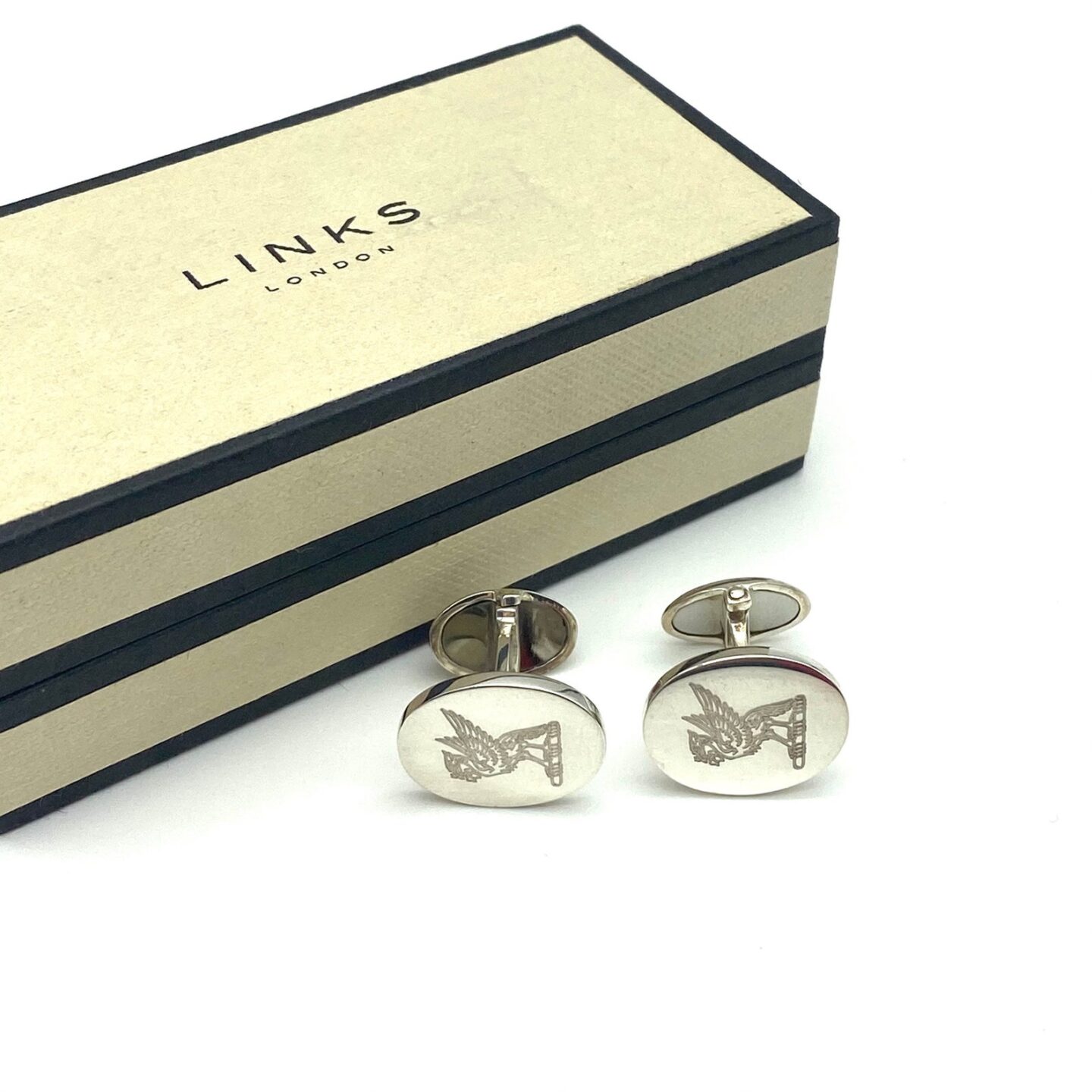 A Links of London box behind 2 silver round cufflinks with an engraved Liver Bird