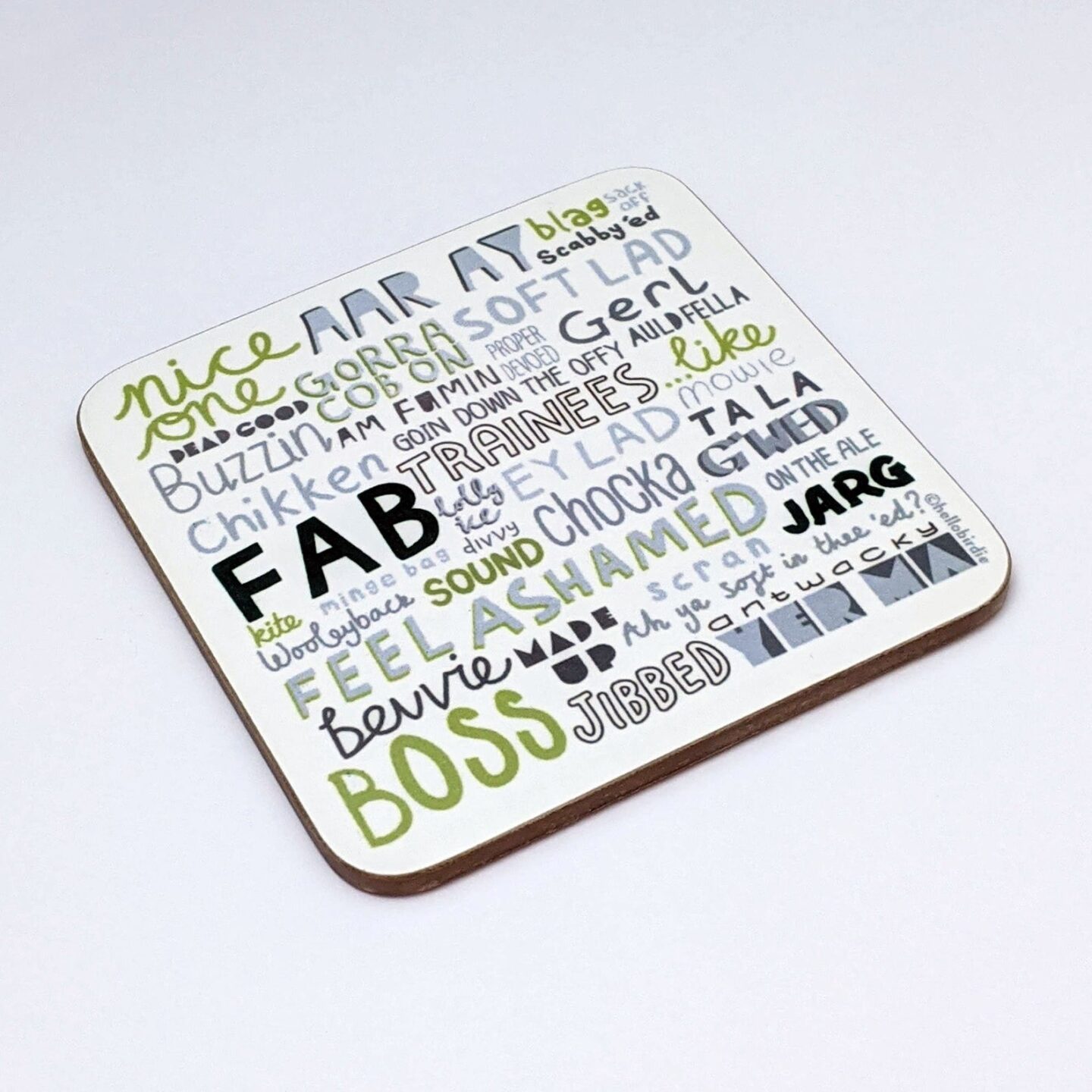 A white coaster with grey, black and green writing in different fonts depicting a selection of Liverpool slang